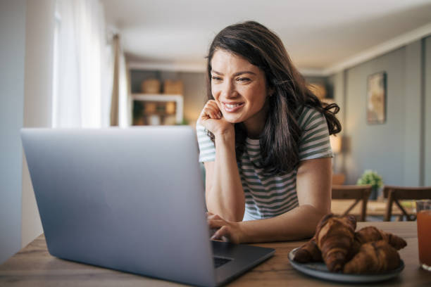 istock Beautiful smiling woman using laptop at home. 2030236495