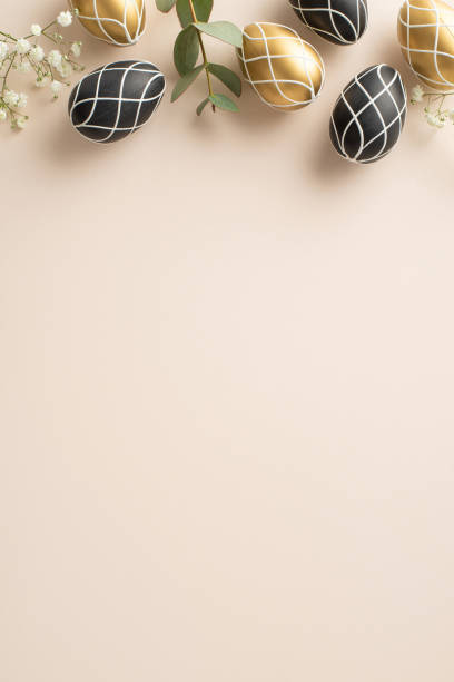 istock Sophisticated Easter motif: Top-view vertical photo featuring exquisite black and gold eggs, natural eucalyptus foliage, gypsophila flowers, set against a light beige backdrop, with space for copy 2030247141