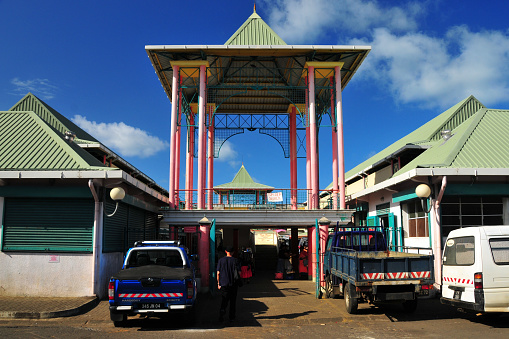 Mahébourg, Grand Port District, Mauritius, Mascarene Islands: gazebo-like main entrance gate to Mahebourg central market, with commercial vehicles on Rue de La Colonie.