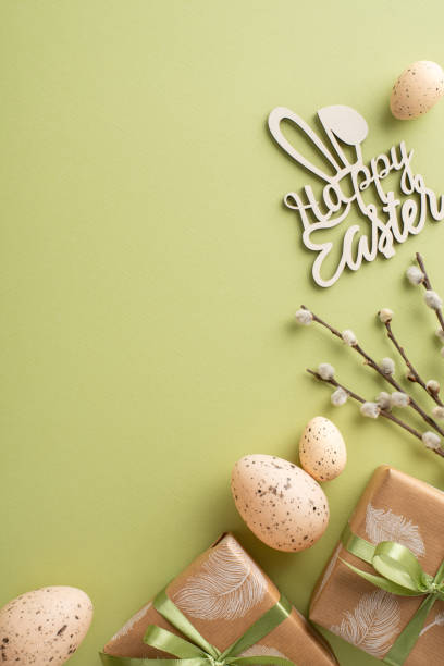 Rustic Easter motif proposal. Top view vertical shot of handmade gift bundles, Easter bunny themed decor, quail eggs, pussy willow cuttings, laid out on green pastel mat with space for copy or adverts