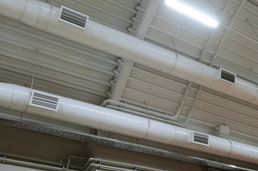 Ceiling ventilation ducts with ventilation grilles. Engineering air system.