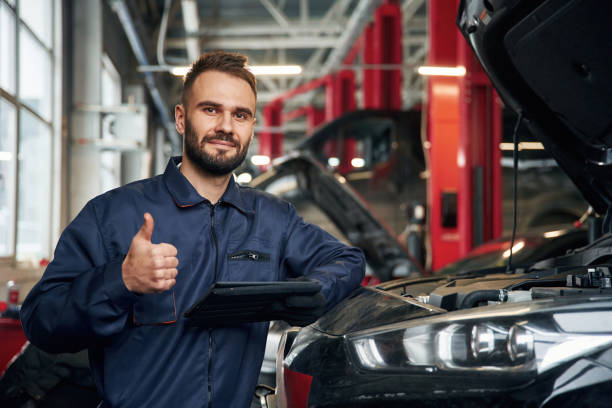 istock Using tablet. Car repairman is in the garage with automobile 2030267836