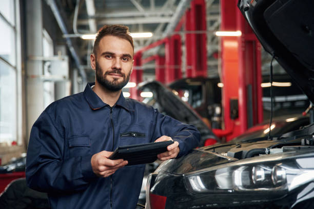 istock Using tablet. Car repairman is in the garage with automobile 2030267861