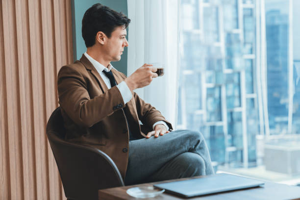 istock Smart businessman holding coffee cup while looking skyscraper view. Ornamented. 2030272623
