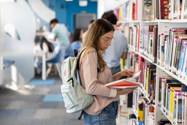 istock Woman searching for a book at a public library 2030273708