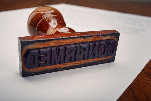 Confirmed - Old wooden office hand stamp on desk