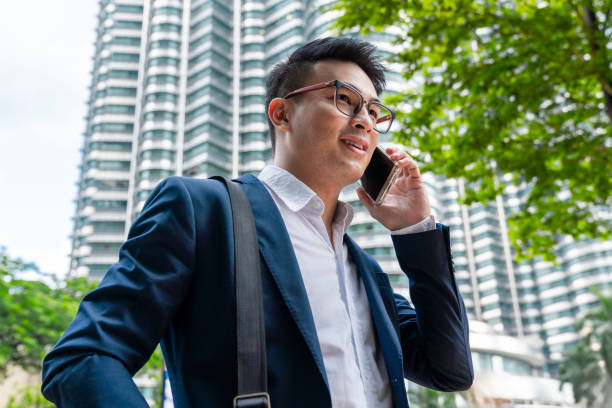 istock Confident Successful Chinese Businessman talking on Mobile Phone 2030298853