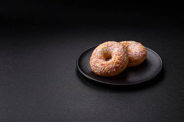 istock Delicious sweet bright donuts with cream on a plain background 2030304857