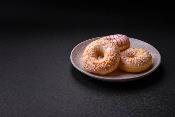istock Delicious sweet bright donuts with cream on a plain background 2030305382
