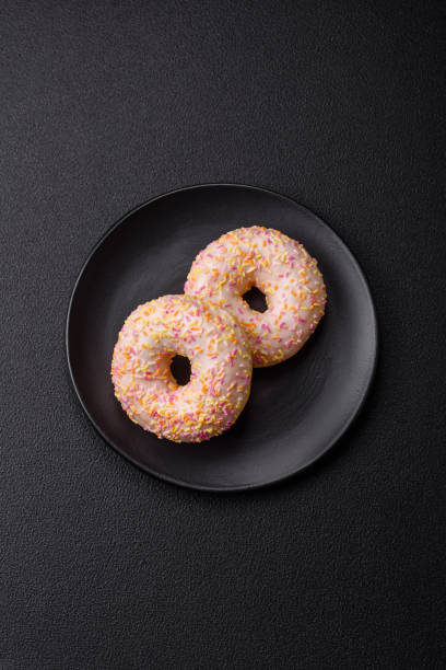istock Delicious sweet bright donuts with cream on a plain background 2030305387