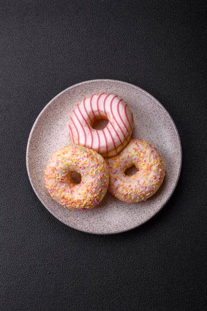 istock Delicious sweet bright donuts with cream on a plain background 2030305900