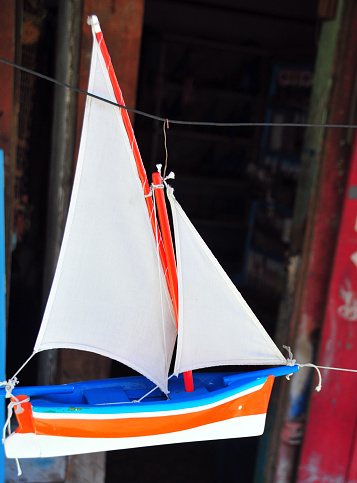 Mahébourg, Grand Port District, Mauritius, Mascarene Islands: miniature Mauritian pirogue, the traditional sailboat of the island, hanging on the street in front of a souvenir shop.