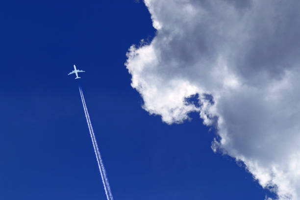 istock a passenger plane with vapour trails high in the blue sky 2030312576