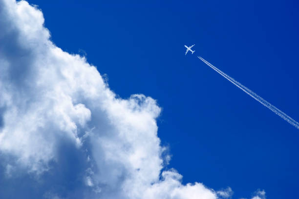 istock a passenger plane with vapour trails high in the blue sky 2030313101