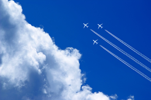 three white passenger airplanes in blue sky