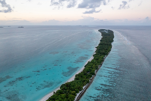 Narrow Island in indian Ocean on Maldives in the evening aerial view, Dhigurah