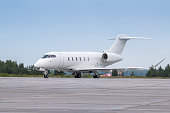 White luxury business jet taxiing on airport taxiway
