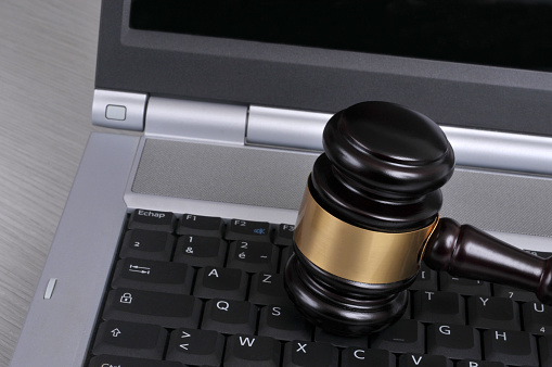 Justice concept with a judge gavel on a laptop keyboard close-up
