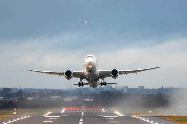 Airplanes taking off and landing during a storm in England - Aircraft leaving on foreground and another one approaching on background - Travel and transportation concepts