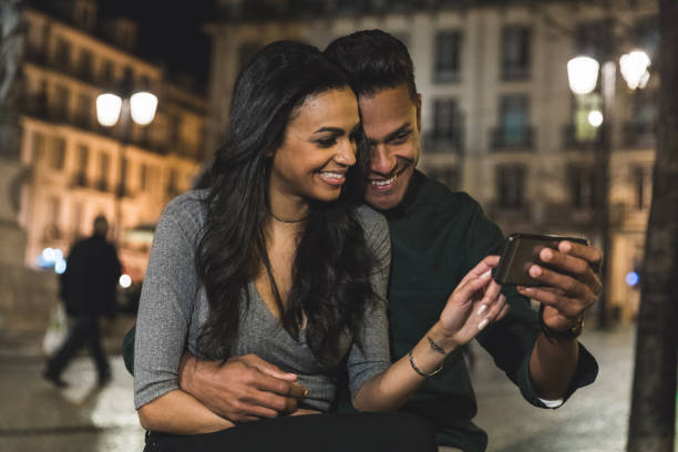 istock Happy multiracial couple sharing a moment with smartphone at night 2030338470