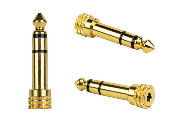 Two gold-plated 3.5mm audio jacks on a reflective gold backdrop, highlighting audio connectivity and tech details. Suitable for music and tech stock photography.