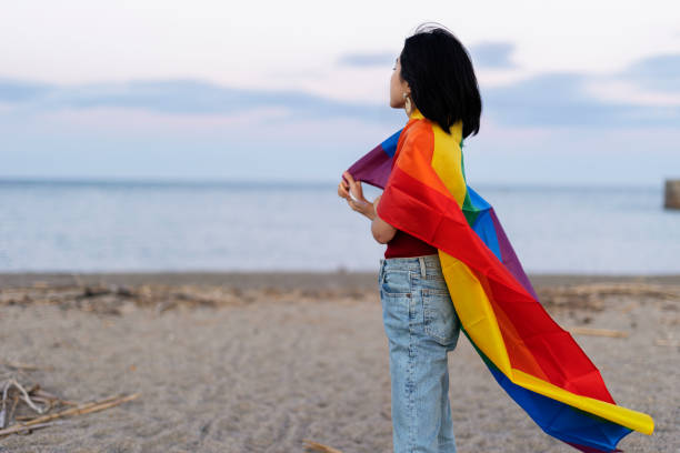 istock Happy girl with a pride flag at the beach. 2030345744