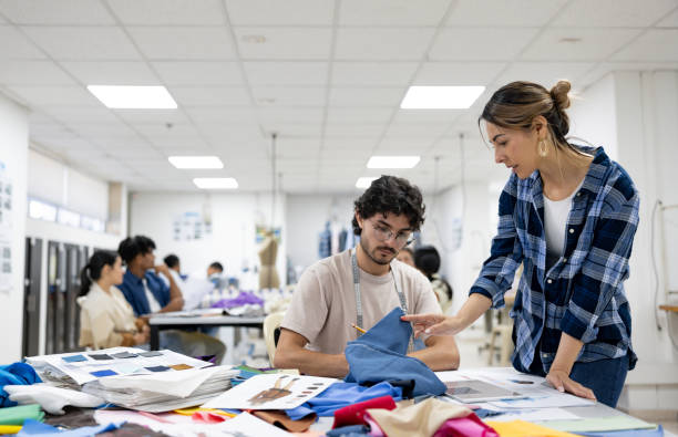 istock Teacher discussing fabrics with a fashion design student in class 2030353197