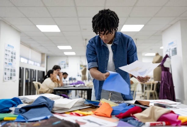 istock Fashion student selecting fabrics for his design in a textile class 2030353211