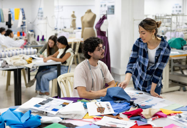 istock Teacher teaching a student about fabrics in a textile class at university 2030353235