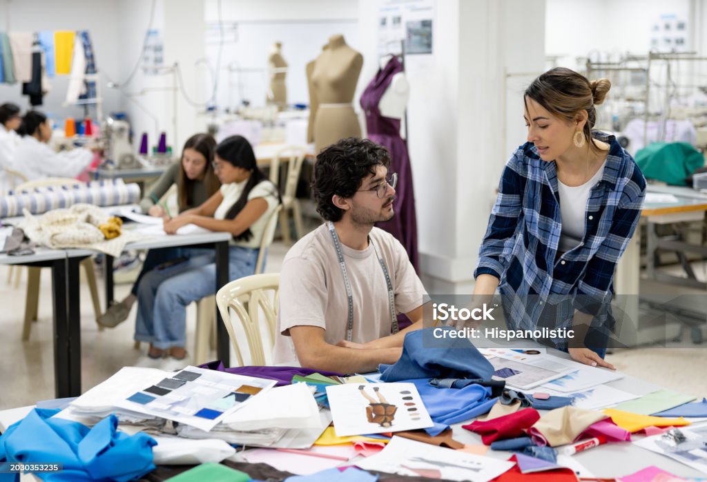 Teacher teaching a student about fabrics in a textile class at university Teacher teaching a Latin American student about fabrics in a textile class at university - education concepts Fashion Stock Photo Teacher teaching a student about fabrics in a textile class at university Teacher teaching a Latin American student about fabrics in a textile class at university - education concepts Fashion Stock Photo
