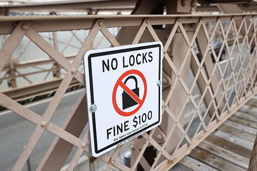 Love locks, or padlocks inscribed with couples' names or initials are attached to the Brooklyn Bridge in New York, N.Y., Saturday, Jan. 27, 2024. The practice has been banned on the bridge as the weight of the locks can cause structural damage to the bridge and pose a safety risk. (Photo: Gordon Donovan)