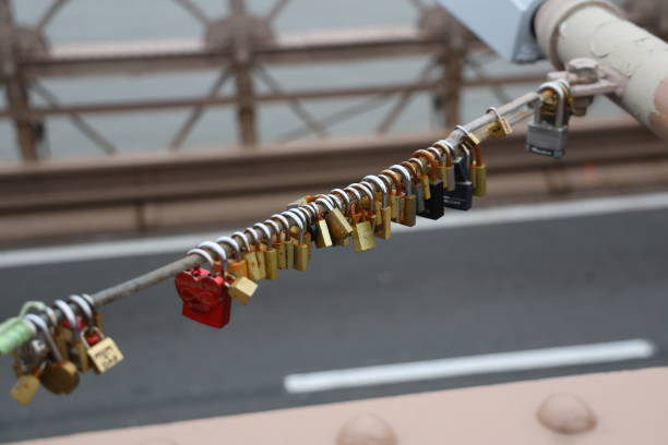 Love locks, or padlocks inscribed with couples' names or initials are attached to a lamp cable on the Brooklyn Bridge in New York, N.Y., Monday, Jan. 15, 2024. The practice has been banned on the bridge as the weight of the locks can cause structural damage to the bridge and pose a safety risk. (Photo: Gordon Donovan)
