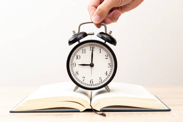 A book and a clock on the desk.
