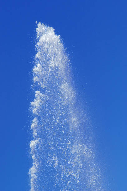 Water from a fountain in the blue sky