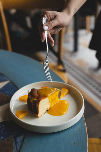 istock Appetizing Basque cheesecake with mango sauce on a stylish retro plate 2030370172
