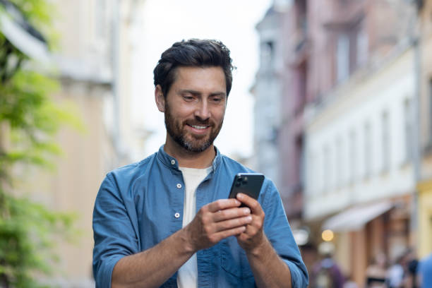 istock Mature beard man using smartphone on city street in the evening light 2030373558