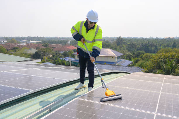 istock Professional engineer cleans solar panels with brush and washes with water on roof structure of construction factory. The technician uses a mop to clean the dirt and dust. green electric power technol 2030379718