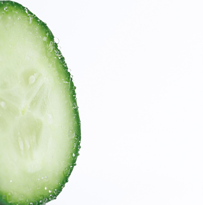 macro slice of cucumber isolated on white background