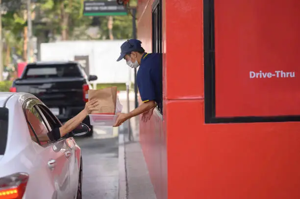 Photo of Men are picking up food from drive-thru counters and taking it out to eat at homes and offices.
