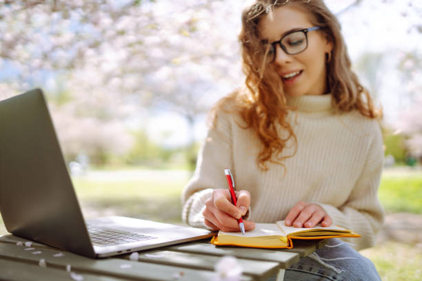 istock Young woman with coffee cup reading book outdoor. 2030417358