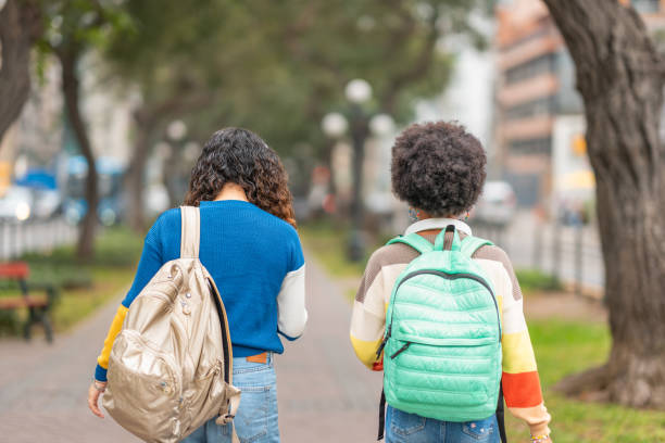 istock Female students with their backs turned walking with their backpacks 2030429305