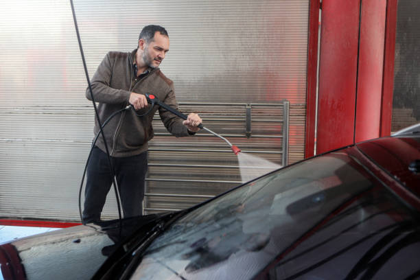 istock Man washing his car in a self service car wash 2030437290