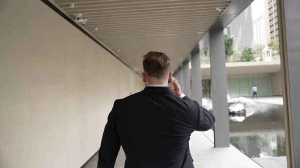 istock Happy project manager talking to phone while walking at modern corridor. Urbane. 2030470808
