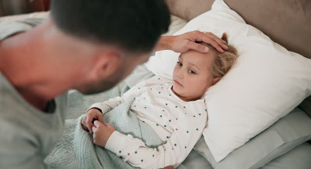 Sick, father and girl recover with disease, bed and hands on ill kid, fever and care with illness. Male parent, dad and daughter with concern, temperature and flu in bedroom with child, home and cold