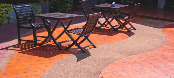 istock 2 wooden coffee table sets on brown tile floor with curve pattern of aggregate cobblestone floor decoration in poolside area of vintage resort hotel 2030545376
