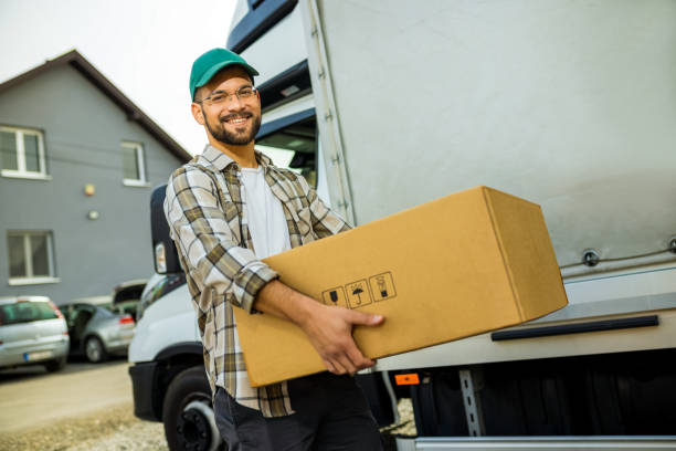 istock Young handsome truck driver carrying package. 2030552234