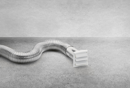 Dryer venting parts pipe and vent cover on a concrete background