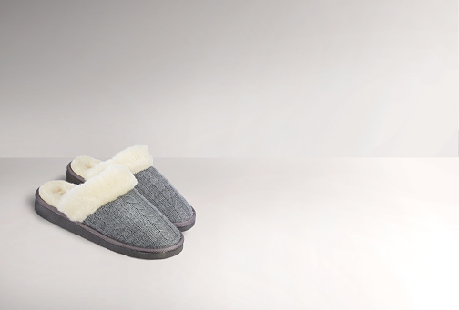 A pair of grey slippers on a white background