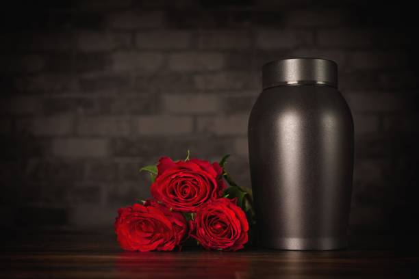 Funeral mourning urn next to a bunch of roses. Funeral mourning urn next to a bunch of roses. cricket trophy stock pictures, royalty-free photos & images