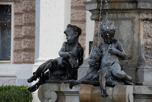 Boy sculptures fishing in water fountain